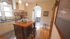 A kitchen with wooden flooring, white cabinets, and pendant lighting. - 3BR Newly Renovated House in the heart of Sturgeon Bay (Sturgeon Bay)