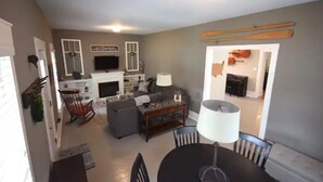 A living room with a fireplace, a television, and a dining area with a table and chairs. - 3BR Newly Renovated House in the heart of Sturgeon Bay (Sturgeon Bay)