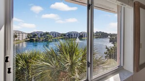 A view from a window overlooking a body of water, buildings, and greenery. - Beach Access Resort Condo with Breath-Taking View (Jupiter)