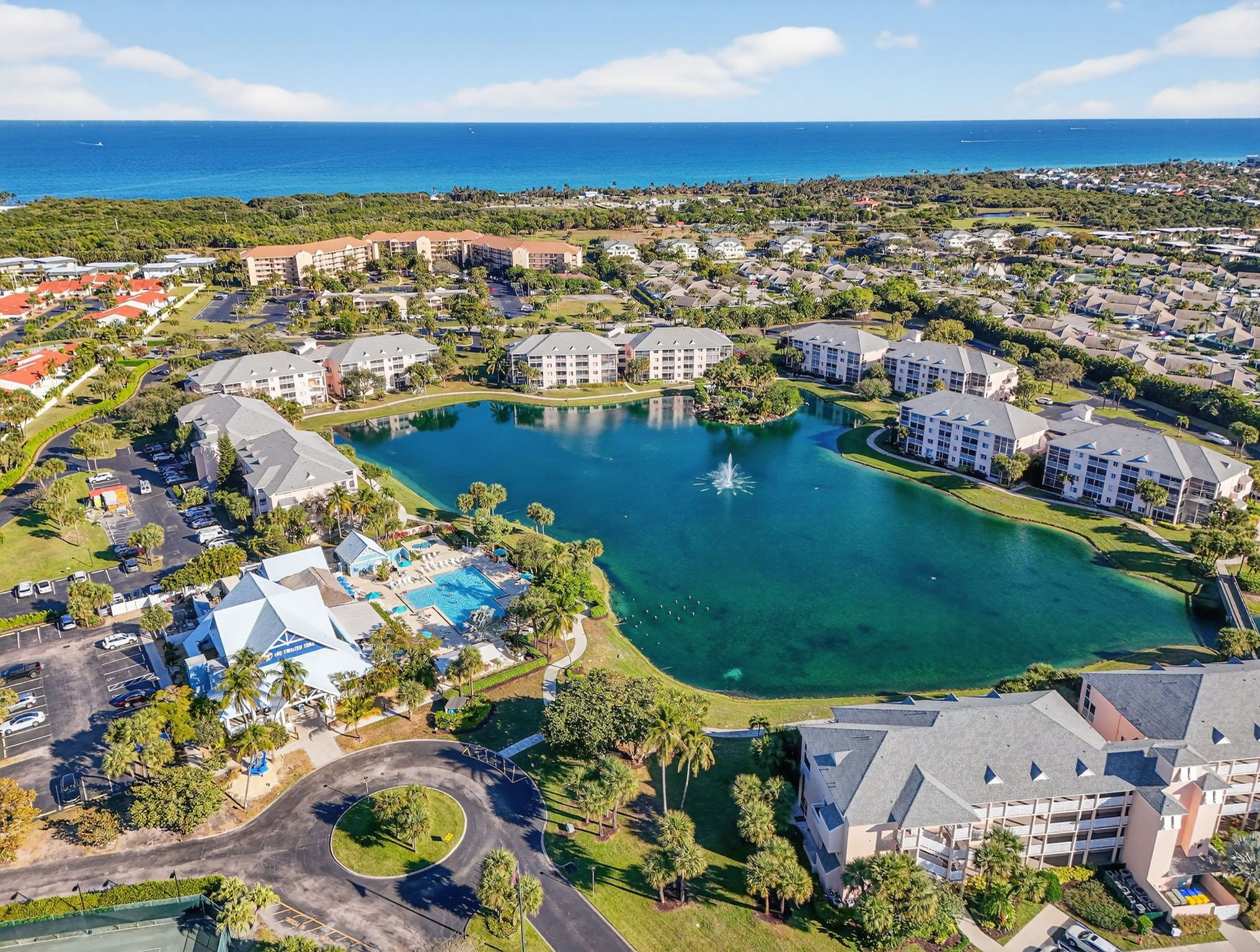 Eine Luftaufnahme eines Resorts mit einem zentralen See, mehreren Gebäuden und einem Yachthafen.