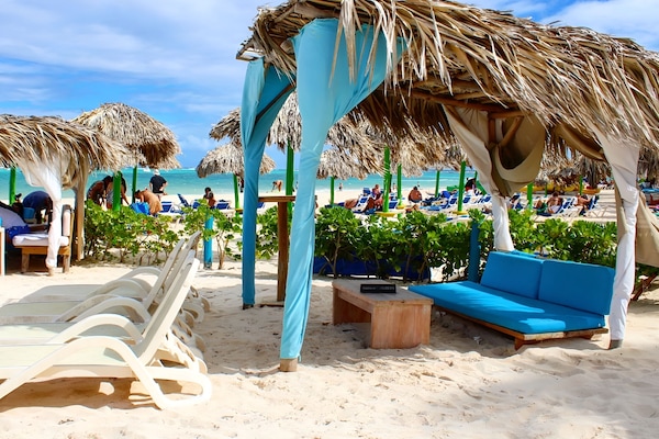 Playa privada, playa de arena blanca, camastros y sombrillas