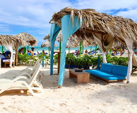 Playa privada, arena blanca, sillas reclinables de playa, sombrillas