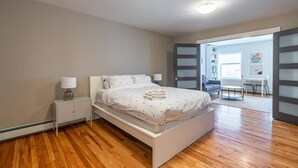 Een slaapkamer met een bed, nachtkastjes, een bureau en een stoel.