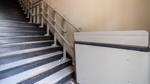A staircase with a handrail and a white object on the right. - Family Friendly Downtown Loft with AC (Halifax)