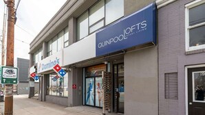 A building with a Domino's Pizza store and a Quipool Luxury Living sign. - Family Friendly Downtown Loft with AC (Halifax)
