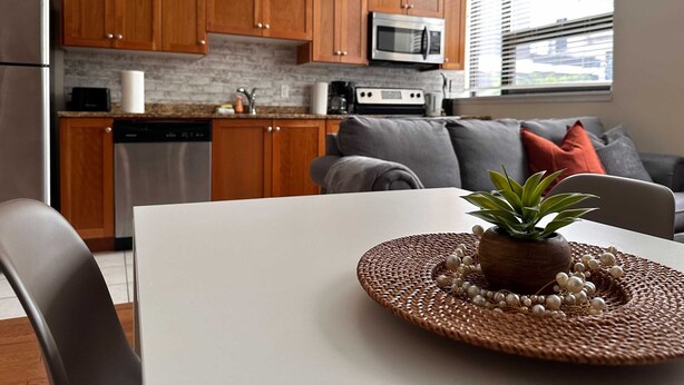 A modern kitchen with wooden cabinets, a microwave, and a dishwasher. - Family Friendly Downtown Loft with AC (Halifax)