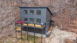 A modern two-story house with a balcony, surrounded by trees. - Private RRG Retreat w/ Hot Tub & Game Room (Stanton)