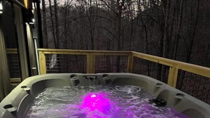 A hot tub with a wooden deck and a view of a forested area. - Private RRG Retreat w/ Hot Tub & Game Room (Stanton)