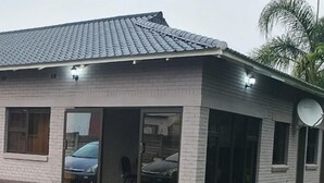 A single-story house with a tiled roof, large windows, and a satellite dish. - The Princess Guest House (Harare)