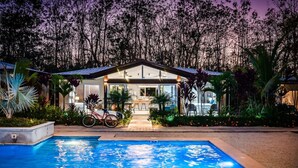 A modern house with a swimming pool, surrounded by tropical plants and trees. - Surfer`s Heaven - Modern, new home, close to beach (Playa Avellanas)