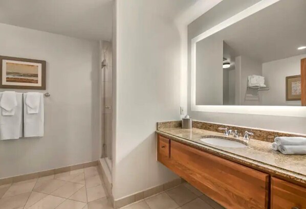 Une salle de bain moderne avec un grand miroir, un meuble-lavabo à deux vasques et une douche.
