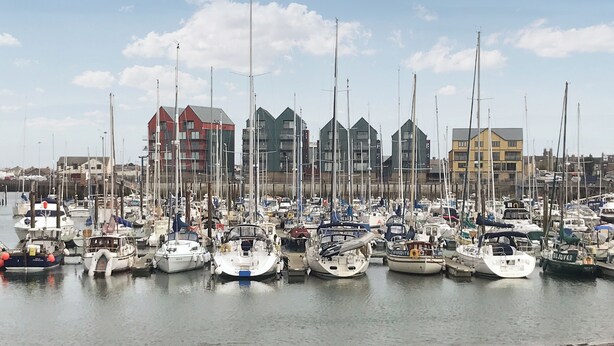 A marina with multiple boats docked, buildings in the background, and a clear sky. - 2 bedroom accommodation in Hadston, near Amble (Hadston, near Amble)