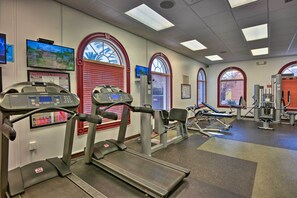 Ein Fitnessstudio mit Laufbändern, Kraftgeräten und Trainingsmatten.