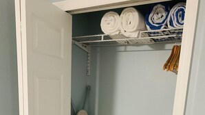 A closet with a hanging rack for towels and a storage shelf. - Beachfront property with pool view-Aloha (Melbourne Beach)