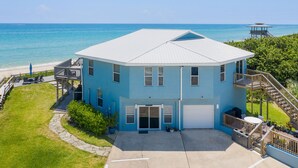 A two-story building with a flat roof, a garage, and a balcony overlooking the beach. - Beachfront property with pool view-Aloha (Melbourne Beach)