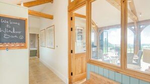 A wooden bench with 'Welcome to Windowover Barn' engraved, a chalkboard with a smiley face, and framed maps on the wall. - 2 bedroom accommodation in Horsham (Horsham)