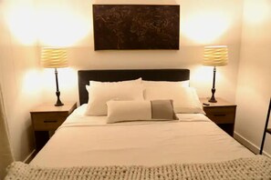 Comfortable sleeping area with a large bed, bedside tables, and a world map above.