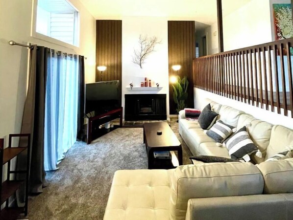 Relax in this cozy living space with a fireplace, flat-screen TV, and comfortable sofa.