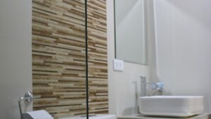 Un baño moderno con inodoro, lavabo y espejo.