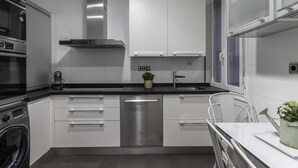 A modern kitchen with white cabinets, stainless steel appliances, and a built-in dishwasher. - Spacious and cosy in a central neighbourhood, Indautxu. (Bilbao)