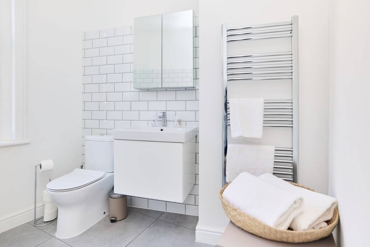 A modern bathroom with a white toilet, a sink, and a mirror.