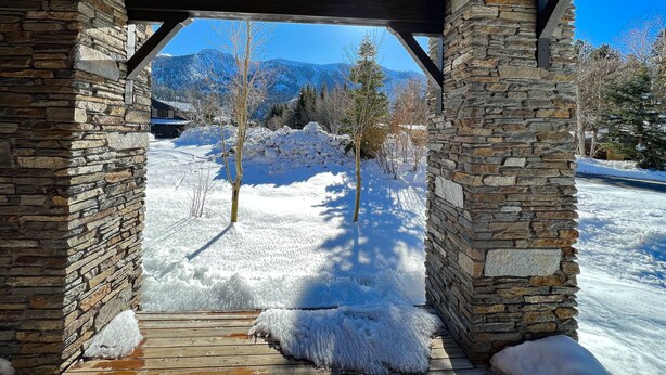 A stone structure with a wooden roof and a view of snow-covered ground and mountains. - Snowcreek Vi The Lodges #1167 4 Bedroom Condo by RedAwning (Mammoth Lakes)