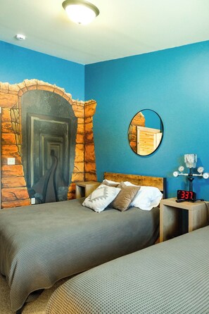 Een slaapkamer met een stenen boog, een bed met hoofdeinde, een nachtkastje met een klok en een spiegel aan de muur.