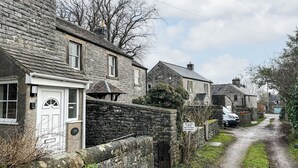 A narrow rural lane with stone houses, a private lane sign, and a gravel path. - 2 bedroom accommodation in Monyash (Monyash)