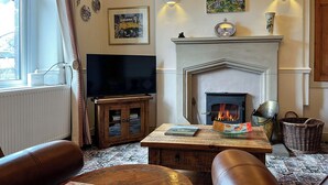 A living room with a fireplace, a television, and a comfortable seating area. - 2 bedroom accommodation in Monyash (Monyash)