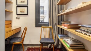 A study room with a desk, two chairs, a bookshelf, and framed pictures on the wall. - Sophisticated Flat in Trendy Poble Sec (Barcelona)