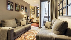 A modern living room with a grey sofa set, a patterned rug, and framed artwork on the walls. - Sophisticated Flat in Trendy Poble Sec (Barcelona)