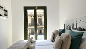 Une chambre d’hôtel avec un lit, des oreillers et une fresque murale représentant le panorama de la ville.