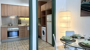 Une cuisine de taille réduite, avec des meubles de rangement en bois, une cuisinière et un lave-linge.
