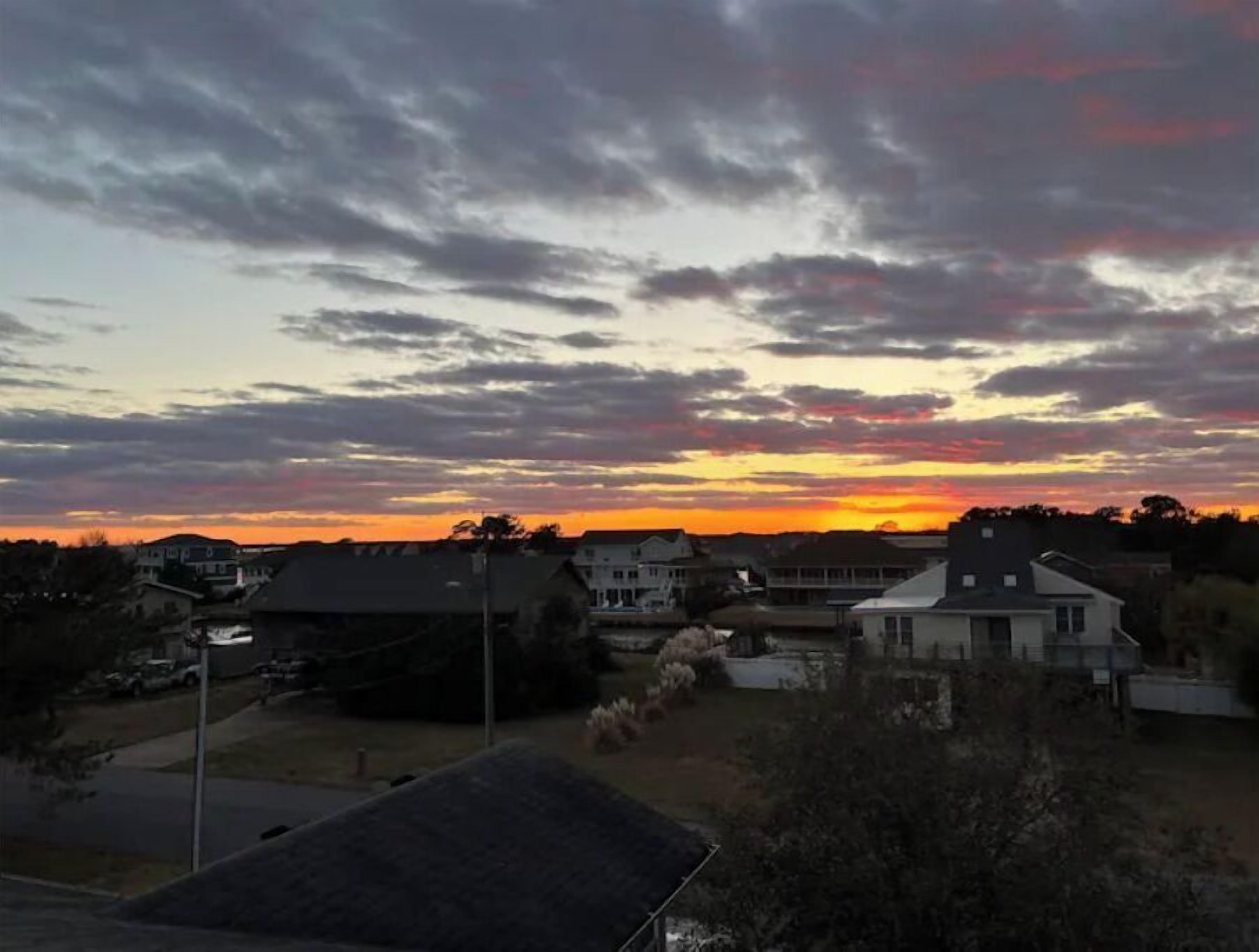 A residential area with houses and a clear sky during sunset.