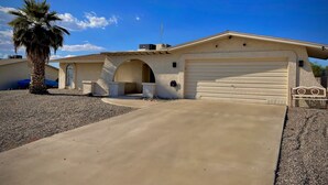 A single-story house with a garage, a covered patio, and a palm tree. - Ended up in Havasu (Lake Havasu City)