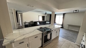 A modern kitchen with a marble countertop, white cabinetry, and a built-in oven. - Ended up in Havasu (Lake Havasu City)