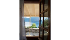 A room with a view of a lake and mountains. - Kalivia House - Entire Home (Skoutari)