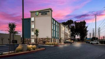 Un hotel con un letrero que dice "Woodspring Suites" y un estacionamiento al frente.