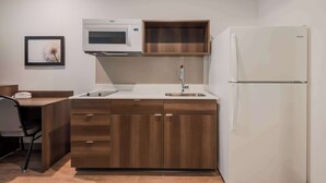A compact kitchen with a microwave, sink, and refrigerator.