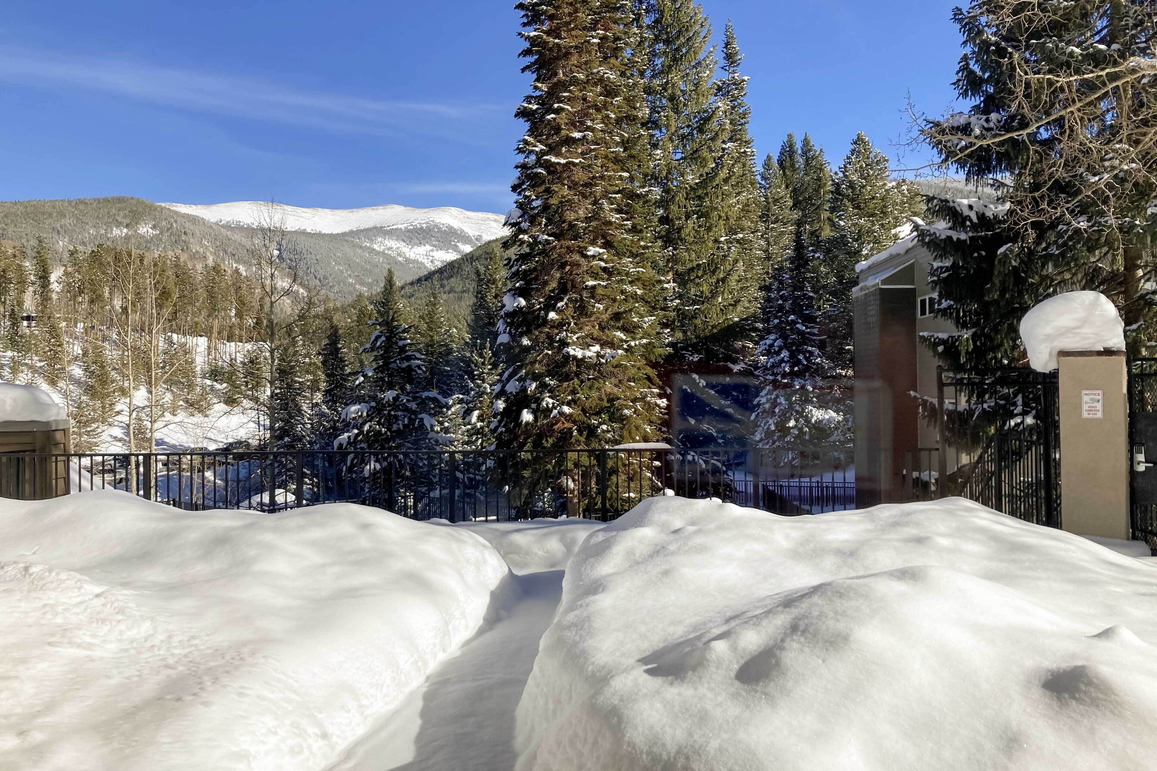 A snow-covered landscape with a building and trees.