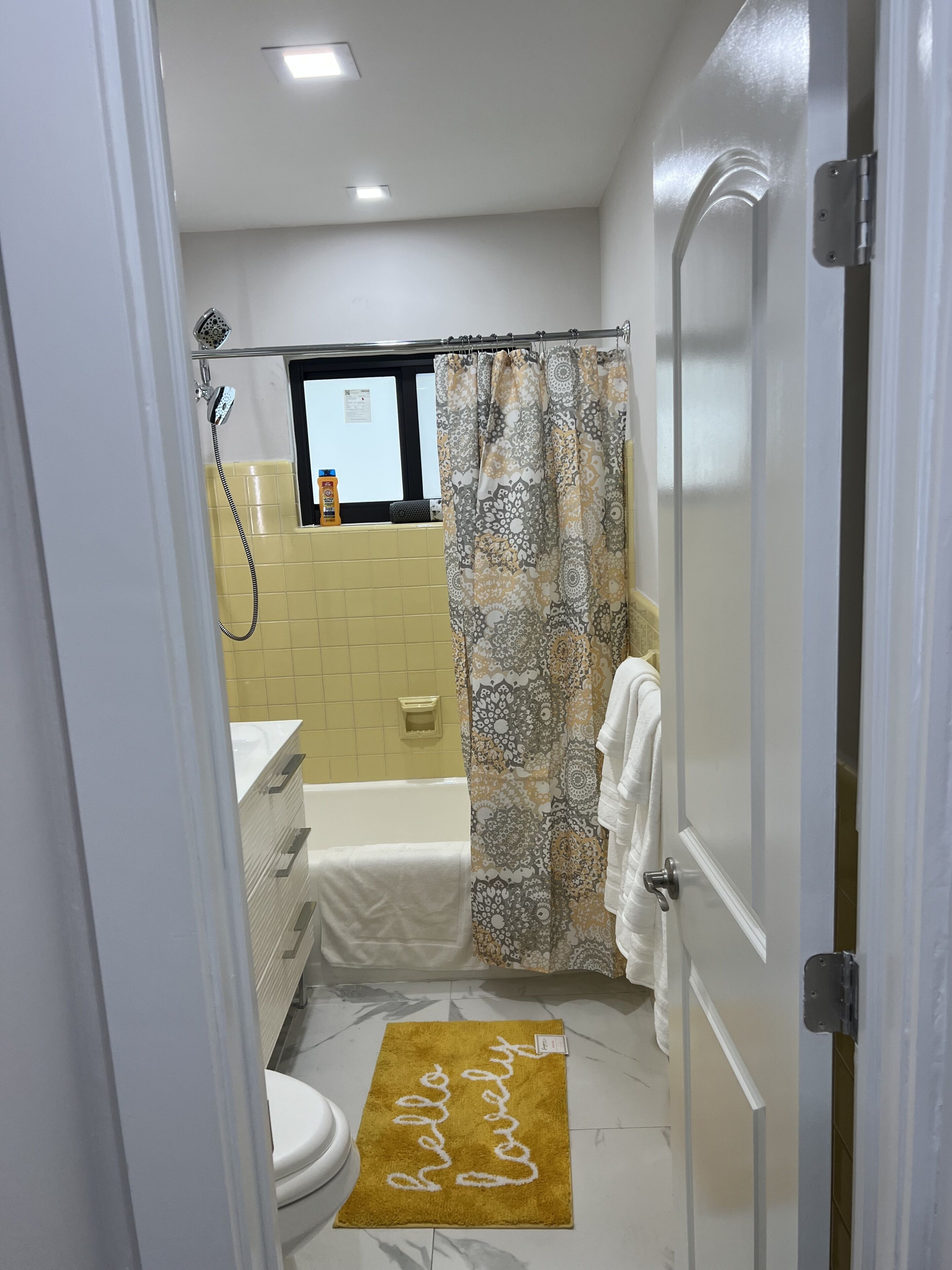 A bathroom with a shower, toilet, and sink.