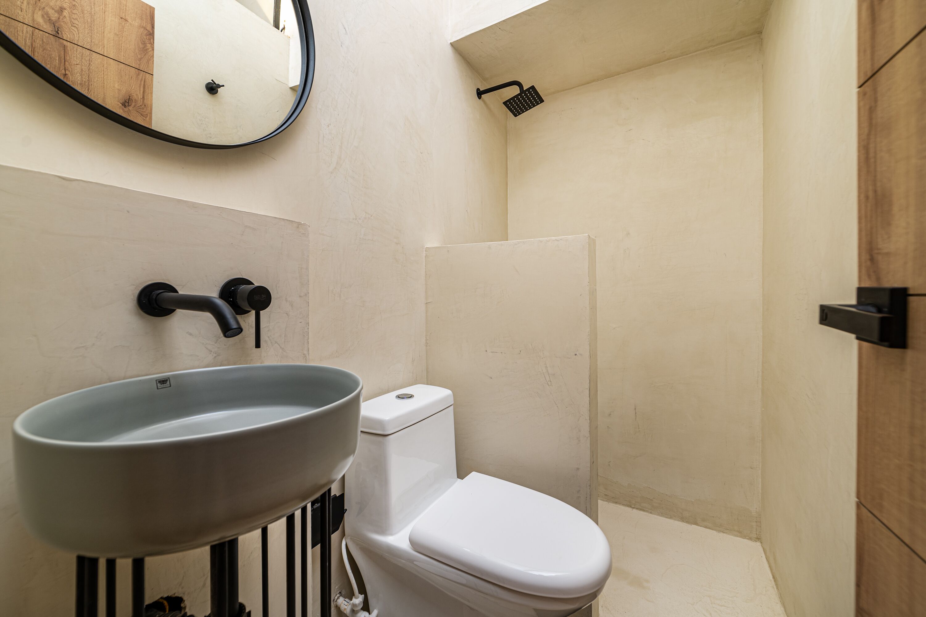 Un baño con inodoro blanco, lavabo y ducha.