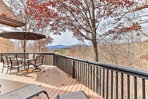 Une terrasse en bois avec des meubles d’extérieur, une table et des chaises.