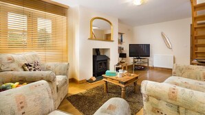 Una sala de estar acogedora con chimenea, televisor y estantería.