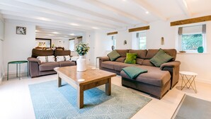 A spacious living room with a wooden coffee table, two sofas, and a patterned rug. - The Old Bakehouse - Within the Helland Barton Farm Collection (Delabole)