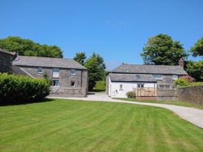 A stone cottage with a gravel driveway and a well-maintained lawn. - The Old Bakehouse - Within the Helland Barton Farm Collection (Delabole)