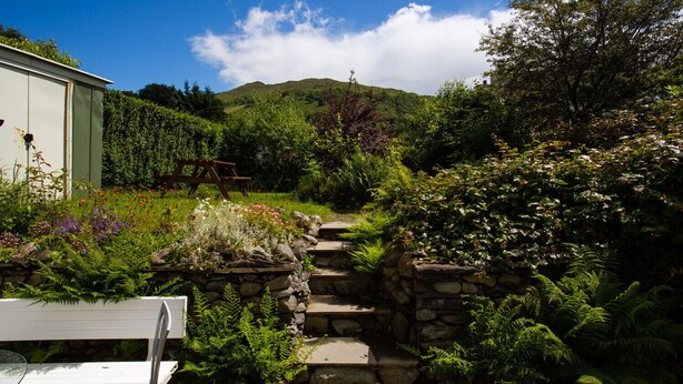 A garden with a stone staircase leading to a wooden bench. - Uldale (Ambleside)