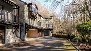 A stone building with a covered driveway and a garage. - Spring Cottage (Ambleside)