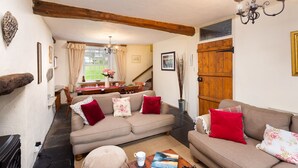Una sala de estar acogedora con un sofá, una mesa con un libro y una chimenea.