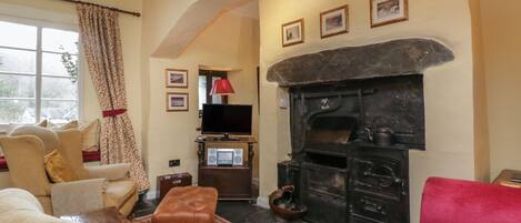 A cozy living room with a fireplace, comfortable seating, and a television.